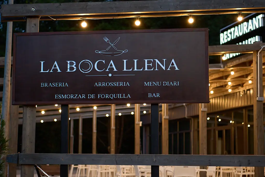 Cartel de madera con el rótulo La Boca Llena y sus especialidades