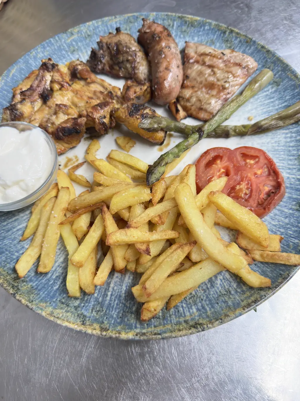 Parrillada de carne a la brasa con patatas y tomate